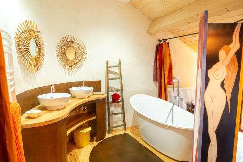 a bathroom with two sinks and a bath tub at Chez mamiethé in Ispagnac