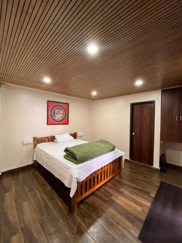 a bedroom with a bed and a wooden ceiling at Zimba Cottage Retreat 2 in Kalimpong