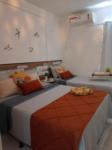 a room with two beds and a white wall at Apto Beira Mar - Enseadas dos Corais in Cabo de Santo Agostinho