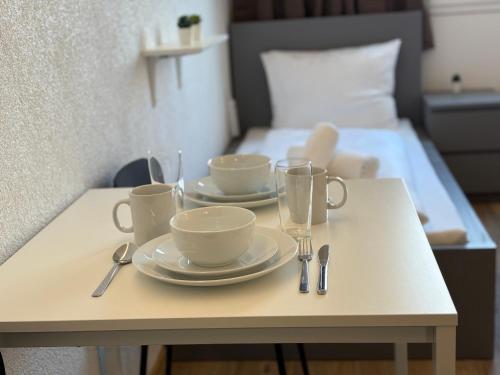 a table with two cups and saucers on it with a bed at Stäy Gronau in Am Berge