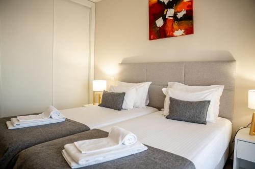 two beds with towels on them in a hotel room at Giramar Apartamentos Turisticos in Lagos