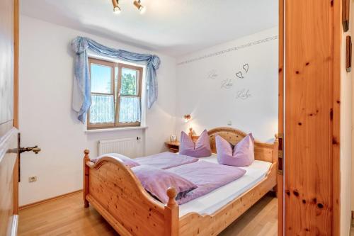 a bedroom with a wooden bed with purple pillows at Ferienwohnung am Schusterhof in Wonneberg
