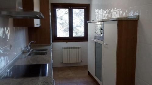 a kitchen with a sink and a refrigerator at Txantxikonea Etxea in Elizondo