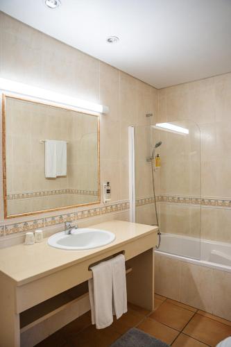 a bathroom with a sink and a shower and a tub at Giramar Apartamentos Turisticos in Lagos