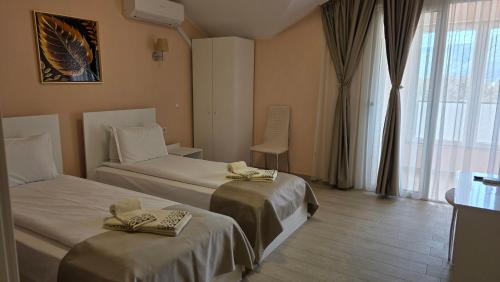 a hotel room with two beds and a window at ALEKSANDAR - luxury stay private guest rooms in Gotse Delchev