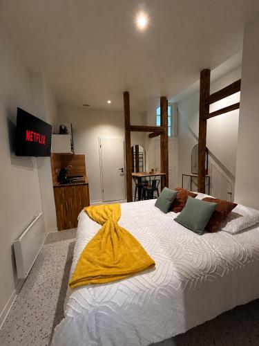 a bedroom with a large bed with a yellow blanket on it at Appartement Central avec Jacuzzi Privé I Strasbnb in Strasbourg