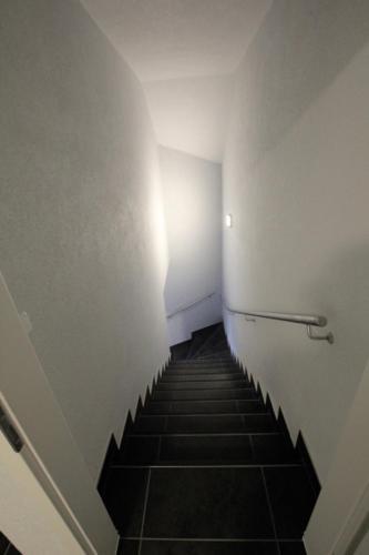 a hallway with a staircase leading up to a white wall at Fewo-Baunatal / Ferienwohnung "Am Pilgerbach" in Baunatal