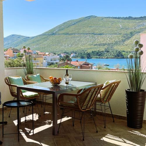 a table and chairs on a balcony with a view at Sea View Apartments in Grebaštica