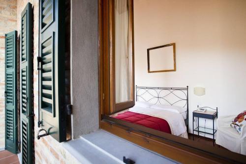 a view of a bedroom with a bed and a mirror at Casa Oliva borgo del Benessere delle Marche in Bargni