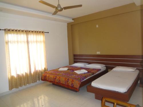 sypialnia z 2 łóżkami i wentylatorem sufitowym w obiekcie Shalimar Residency w mieście Koczin
