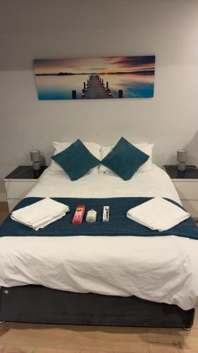 a bed with a blue blanket and pillows on it at The Parade, Market Square room 3 in Northampton
