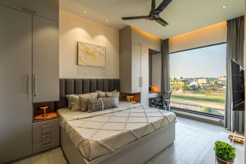 a bedroom with a large bed and a large window at Nirvanika Wellness Luxury Apartments in Rishīkesh
