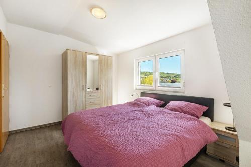 a bedroom with a purple bed and a window at Ferienwohnung Im Tal Olsberg in Olsberg