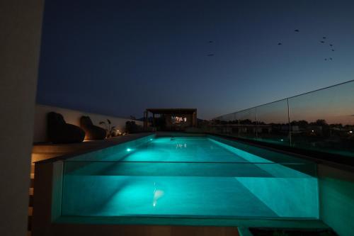 a swimming pool on the roof of a building at night at MINT Keramoti in Keramoti