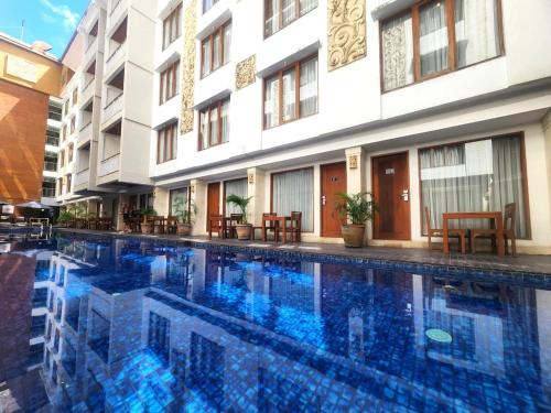 a swimming pool in front of a building at Bali Sun Tropical Hotel & Spa - formerly The Sun Hotel & Spa Legian in Legian
