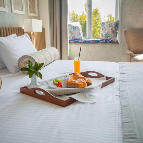 a tray of food and a drink on a bed at Roca Nevada Suites in Villanúa