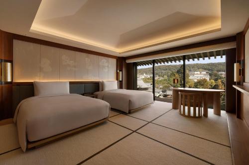 a hotel room with two beds and a window at Capella Kyoto in Kyoto