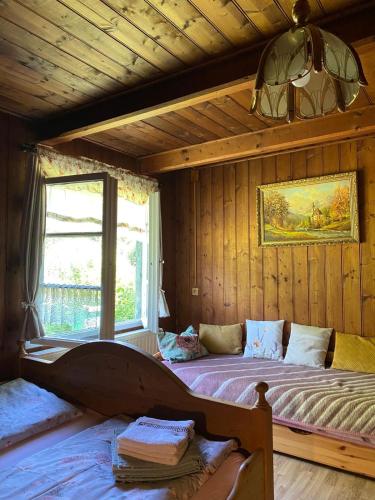 a bedroom with two beds and a window at Chalupa Něža in Petrovice