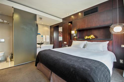 a bedroom with a large bed and a bathroom at Colosseum Hotel in Cape Town