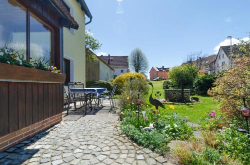 un patio con tavolo e sedie in un giardino di Fritzerhof a Gössweinstein