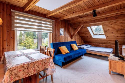 a living room with a blue couch and a table at Nostalgia noclegi in Olsztyn