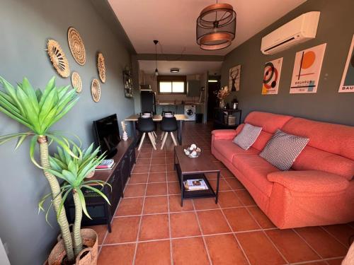 a living room with a red couch and a table at El Mirador de Adrial in Ladrillar