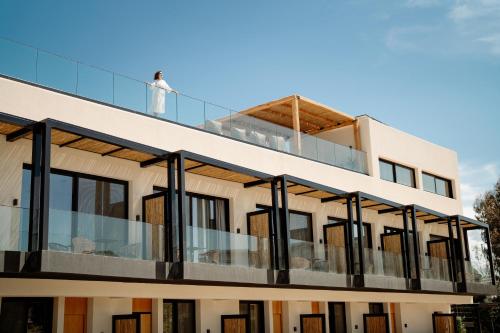 a man stands on the balcony of a building at MINT Keramoti in Keramoti