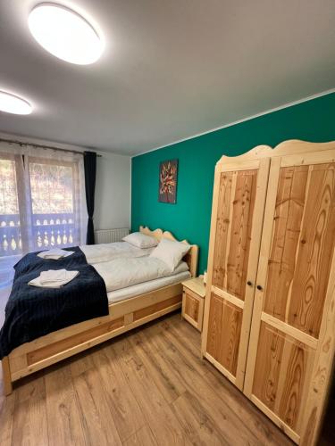 a bedroom with a bed and a green wall at Caesars HOUSE Lac Belis in Luna de Sus