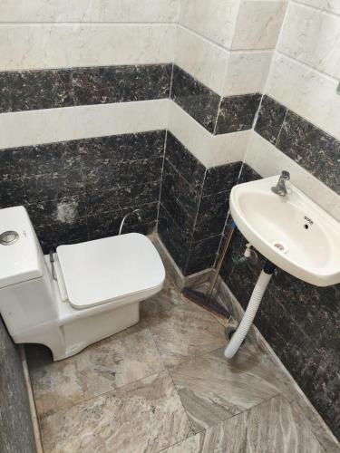 a bathroom with a toilet and a sink at Shri Ved Vrinda Dham Aashram in Chhatikara