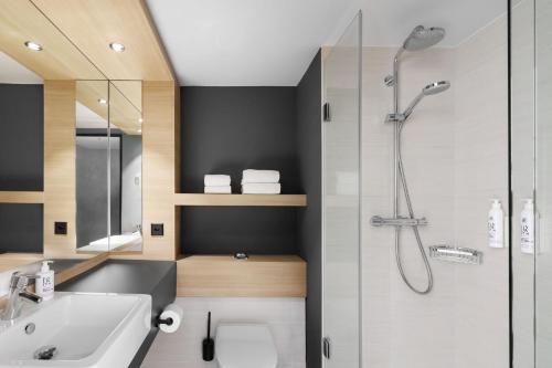 a bathroom with a shower and a sink at Moxy Zurich in Zurich