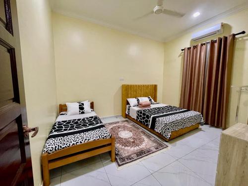 two beds in a room with a window at dayah homestay in Siputih