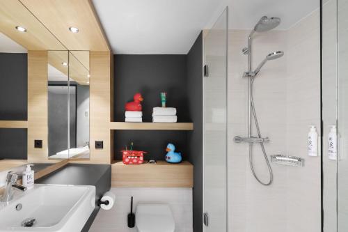 a bathroom with a sink and a shower at Moxy Zurich in Zurich