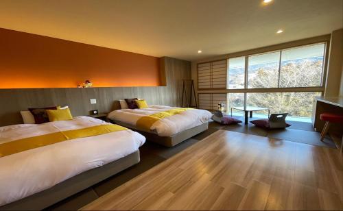 ein Schlafzimmer mit zwei Betten und einem großen Fenster in der Unterkunft Hotel Miyama in Chichibu