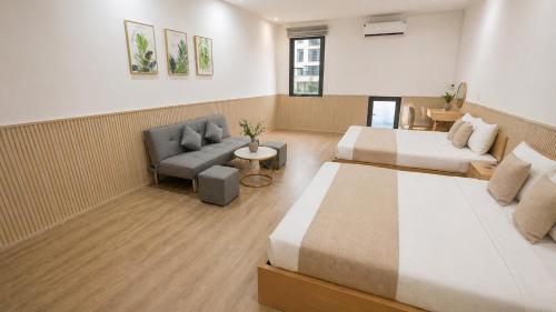 a hotel room with two beds and a couch at Lemon Hotel & Apartment in Danang