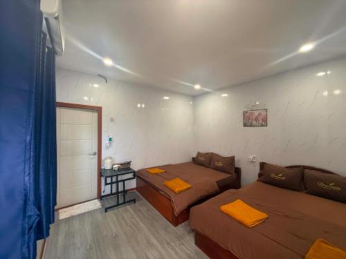 a bedroom with two beds and a small table at Mango Bungalow in Kaôh Rŭng (3)