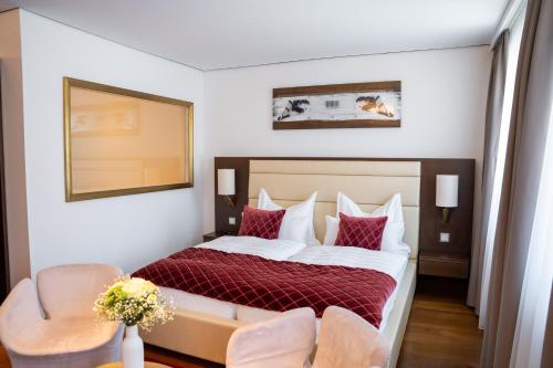 a hotel room with a bed and two chairs at Luxury Boutique Hotel Iris Porsche in Mondsee