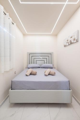 a white bedroom with a bed with two pillows at Angel House in Ialysos