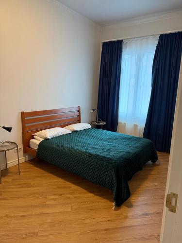 a bedroom with a bed and a window with blue curtains at Spacious 2 bedroom apartment, Old Town Riga in Riga