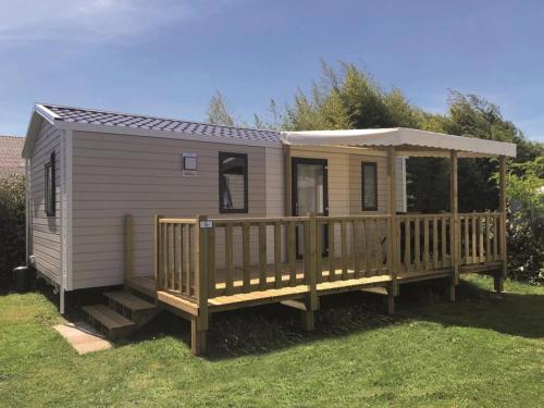 a tiny house with a porch and a deck at Camping 3 étoiles - 1km de la plage - Piscine chauffée et Espace Fitness in Saint-Georges-de-Didonne