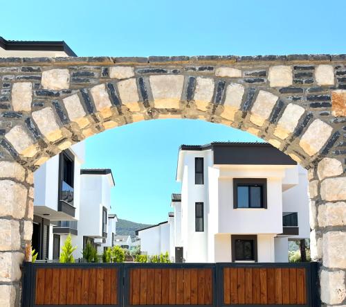 an archway over a fence in front of some buildings at Premium Homes in Didim