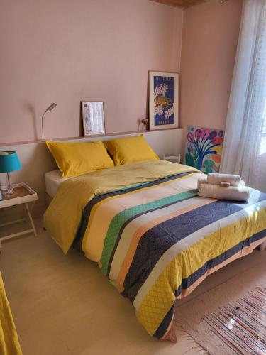 a bedroom with a bed with a colorful bedspread at Échoppe Saint Augustin in Bordeaux