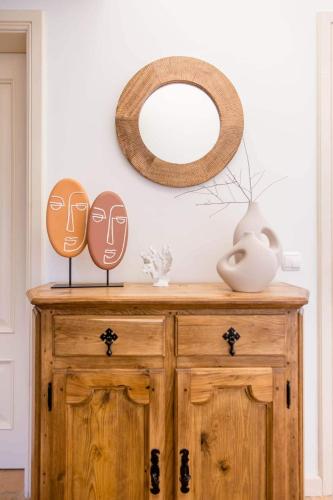 ein Holzschrank mit zwei Masken darauf und einem Spiegel in der Unterkunft Charmante villa Authentique in Loulé