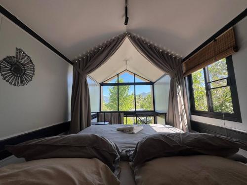a bedroom with a bed and a large window at Duplex House in Chaloklum