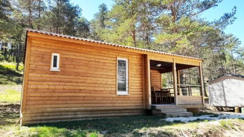 a small log cabin with a porch and stairs to it at ZEcamping 2 avec piscine restaurant vue sur le village de Saint Auban in Briançonnet
