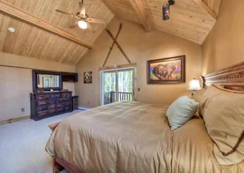 a bedroom with a large bed and a wooden ceiling at Moondance Lodge in Big Sky Mountain Village