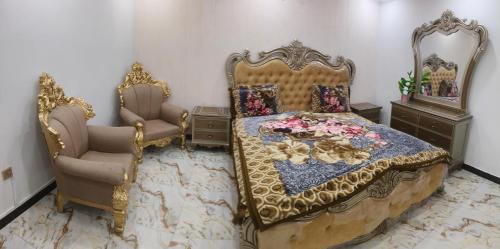 a bedroom with a bed and two chairs at Koh E Sukoon Apartments in Patriata