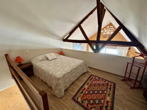 a bedroom with a bed and a large window at Gîte La Thibaud in Lavernat