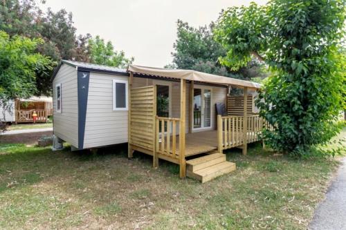 a tiny house with a porch and stairs at ZEcamping 3 étoiles à 4km de la plage piscine chiens acceptés jacuzzi in Bormes-les-Mimosas