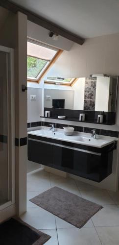 a bathroom with two sinks and a large mirror at Villa du Marais in Ri