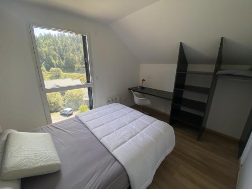 a bedroom with a bed and a large window at Duplex 3 chambres Etoile du sud in Le Lioran